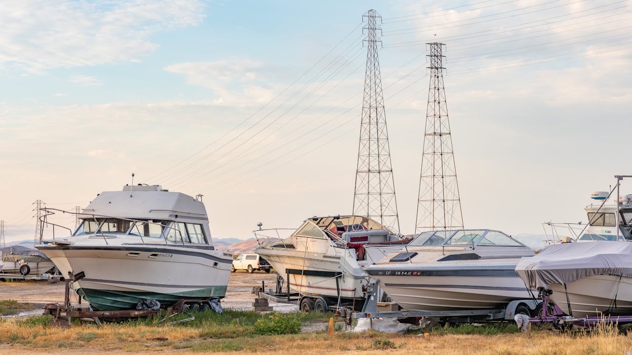 A serene scene of multiple boats on a dry dock with clear blue skies in the background.